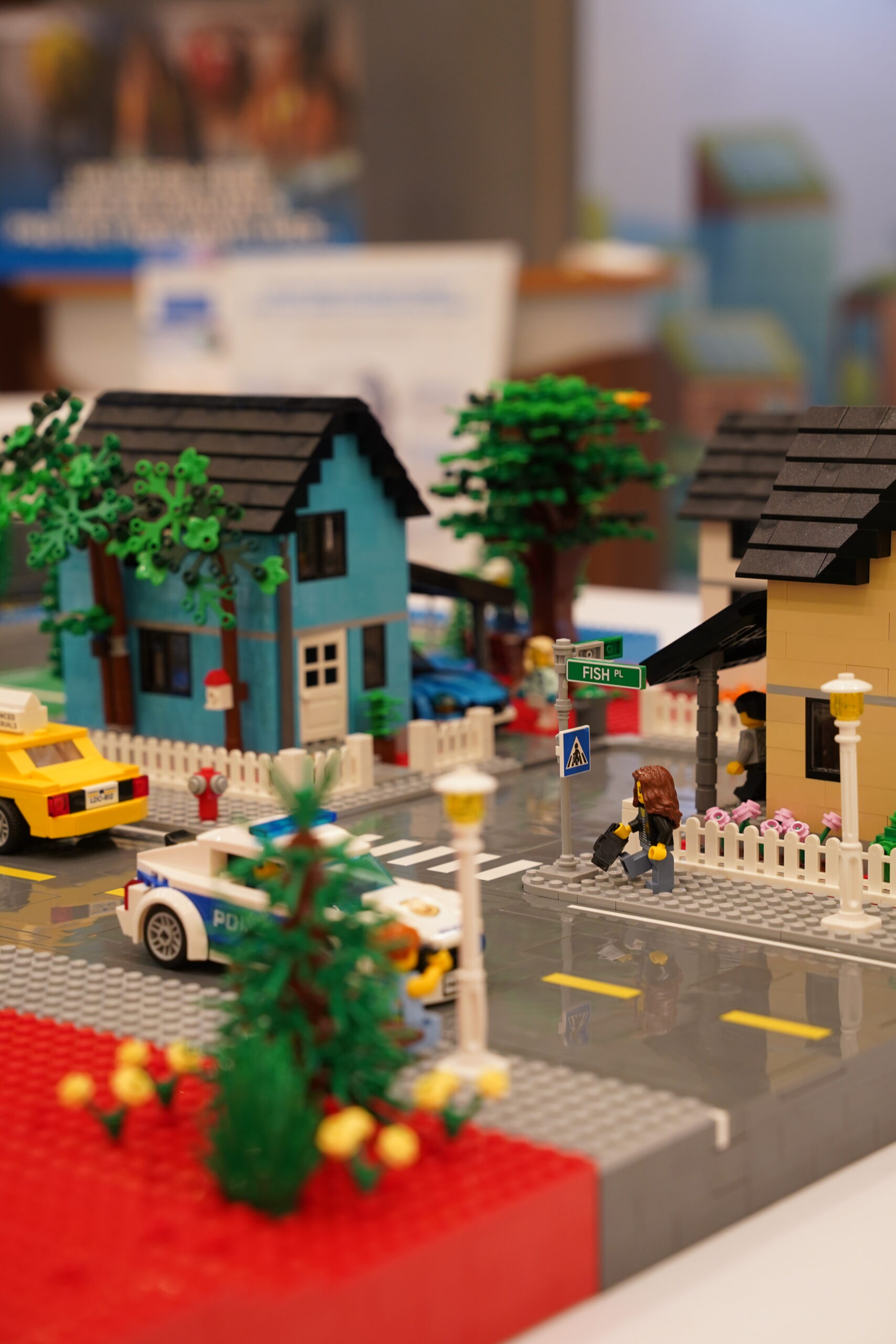 Close-up of a Huber Advanced Materials branded LEGO taxi driving through the model city