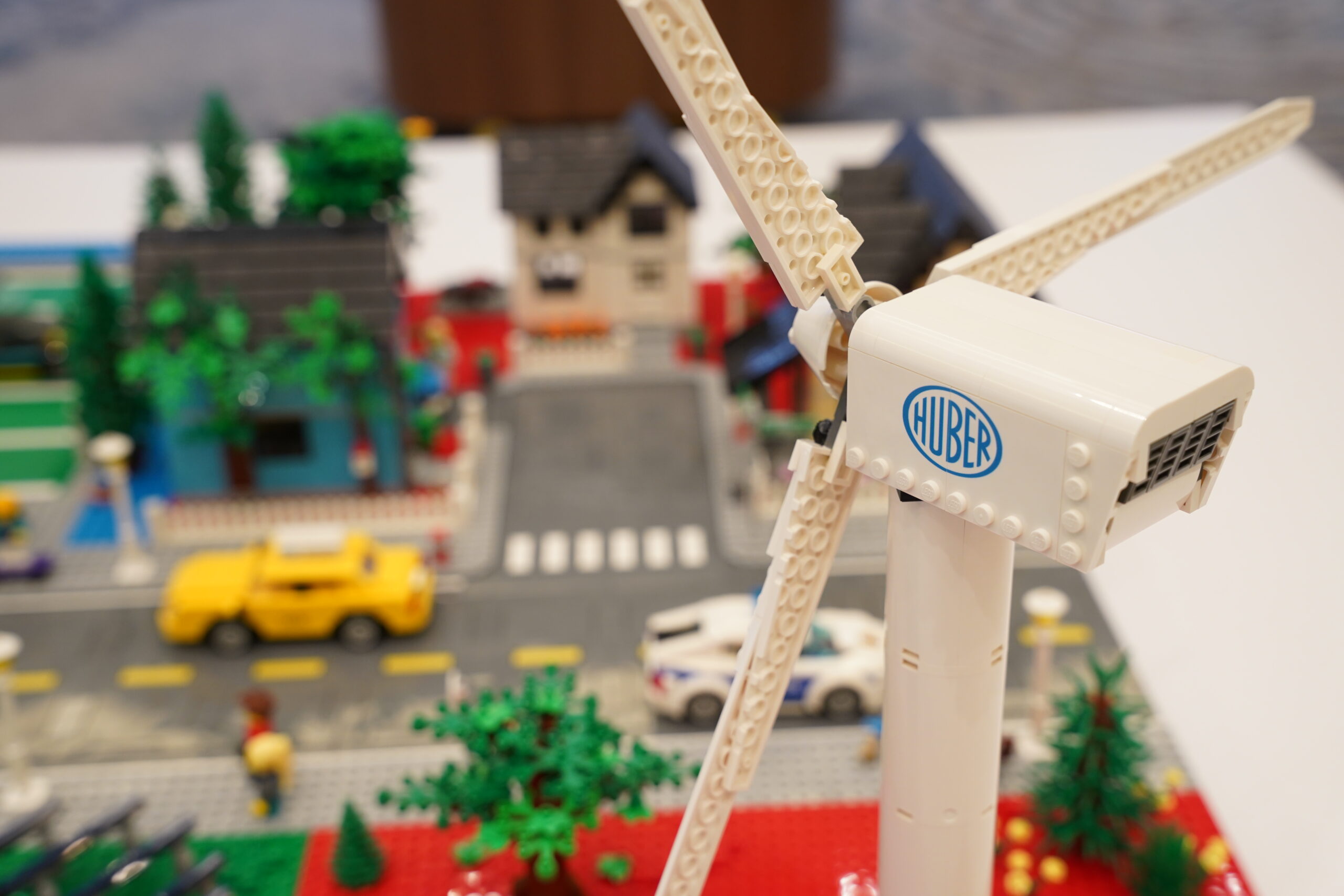 Close-up of the Huber logo printed on a LEGO wind turbine within the city display