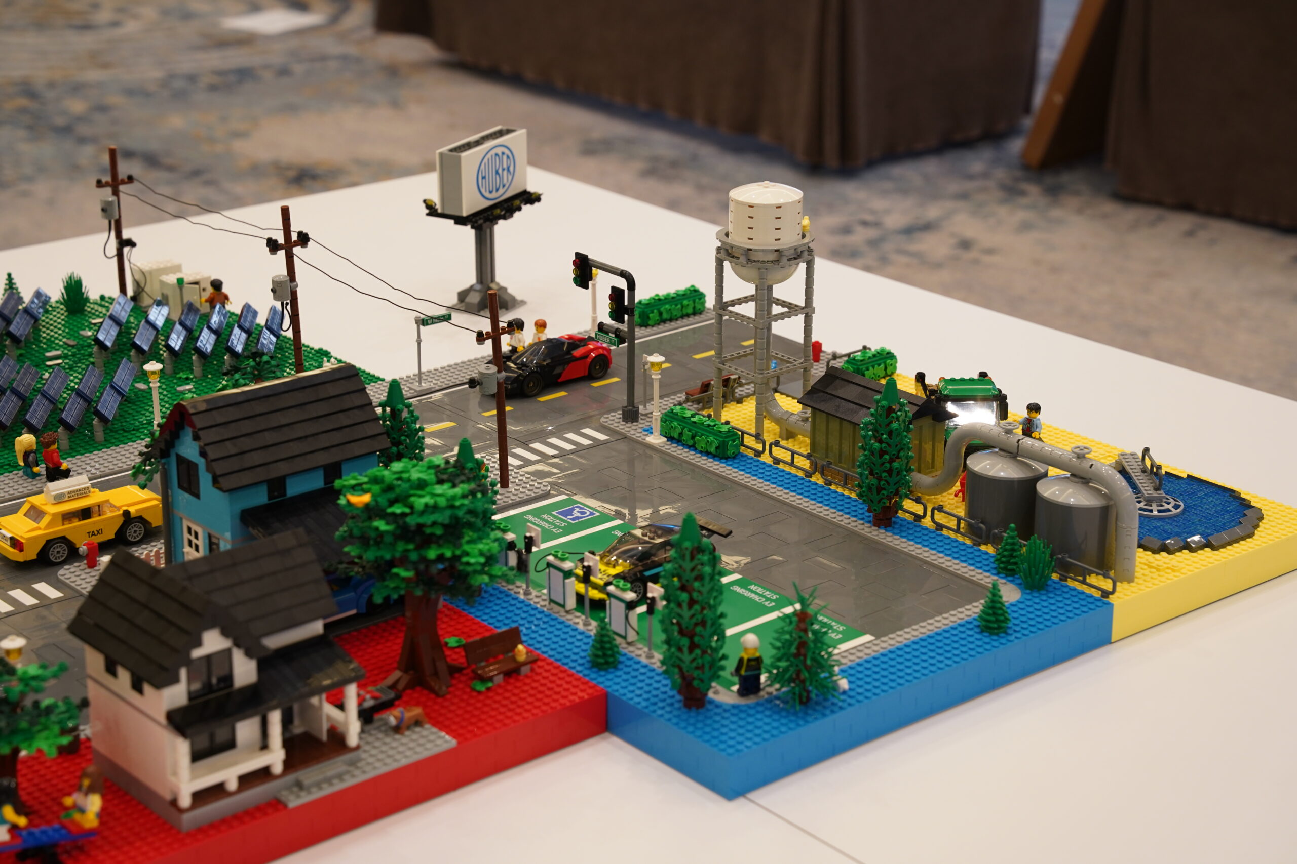 Overhead view of the modular Huber LEGO city with roads, homes, utilities, and branded signage