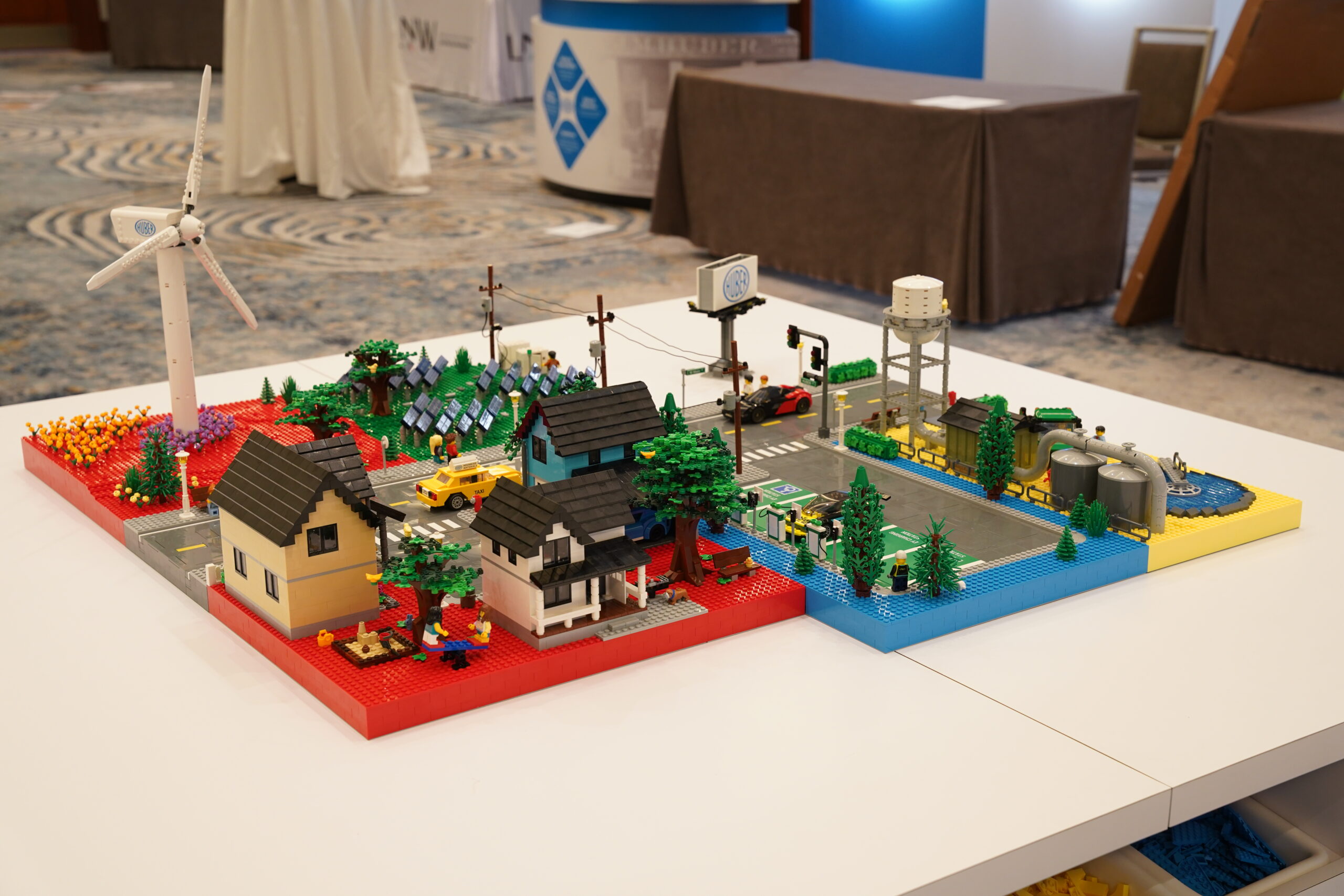 Full view of the custom modular Huber LEGO city display on a white table at HUBERpalooza