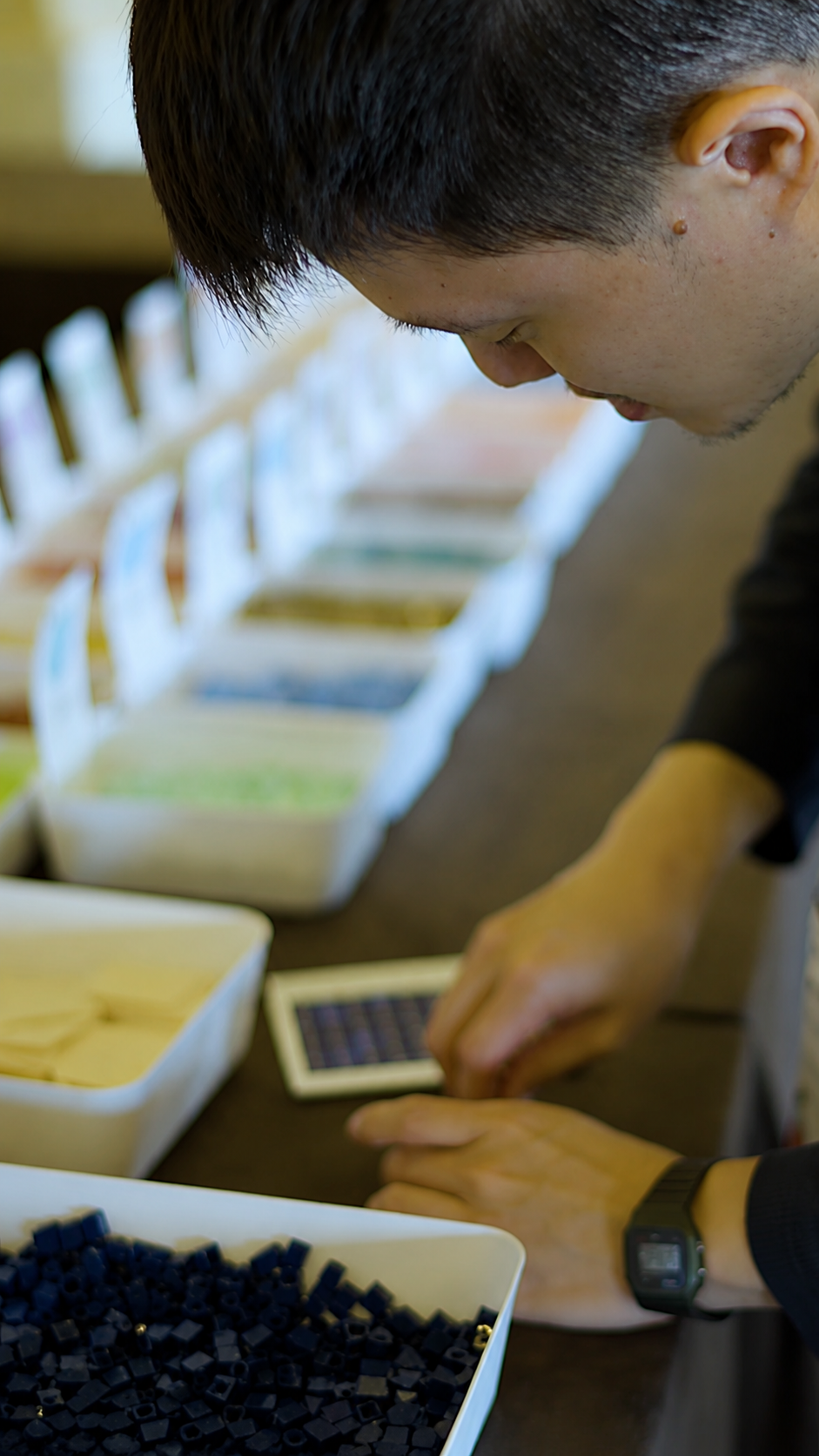 A participant selecting pieces from color-sorted bins for the SAS Innovate mosaic
