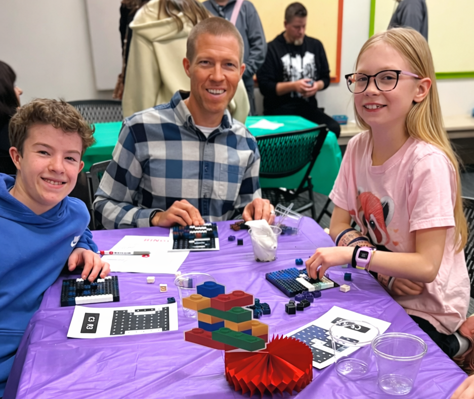 A family building an individual LEGO mosaic section at Victory of the Lamb