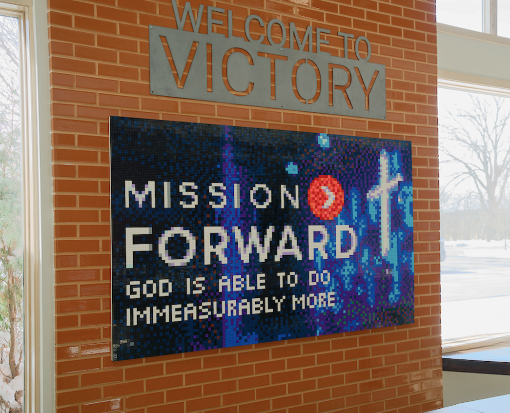 The finished Mission Forward LEGO mosaic installed on the wall at Victory of the Lamb